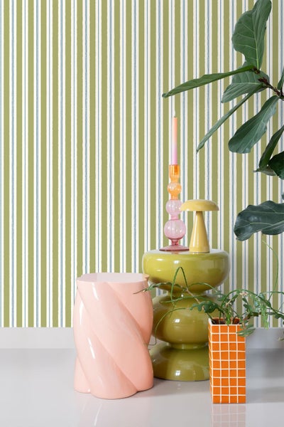 Dekoratives Interieur mit gestreifter Tapete, Beistelltisch und Zimmerpflanzen für ein gemütliches Raumambiente.