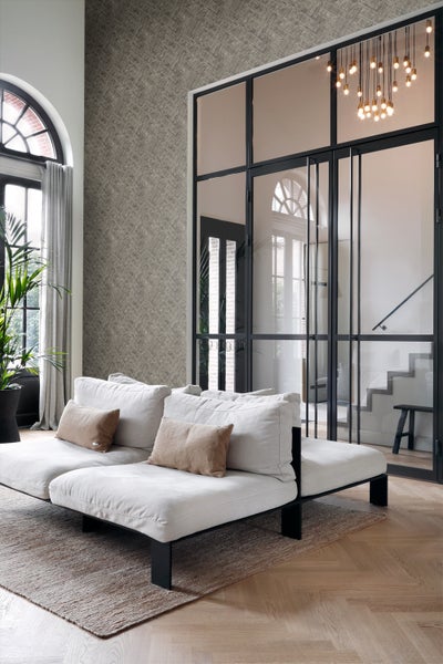 Heller Wohnraum mit Sofa, Teppich, Tapete und Glastür