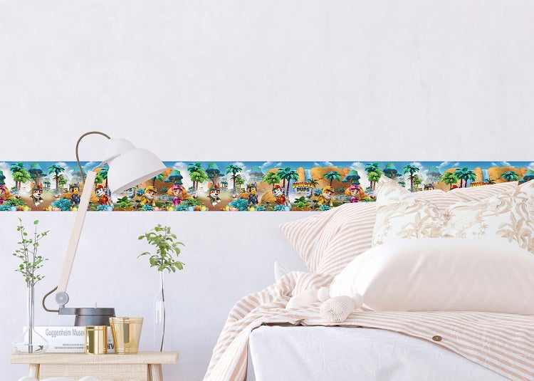 Wandbordüre mit Paw Patrol Jungle Pups Motiven in einem hellen Kinderzimmer über einem Bett.