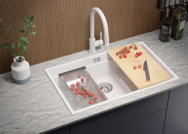 Küchenspüle mit Abtropfschale, Schneidebrett, Armatur und Dekoration auf einer Küchentheke
