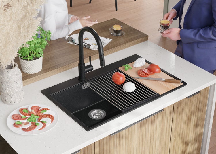 Küchenszene mit Spüle, Armatur, Schneidebrett, Tomaten, Mozzarella und Personen