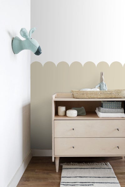 Helles Kinderzimmer mit Wickelkommode, Textilien und Wanddekorationen für eine freundliche Atmosphäre