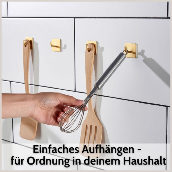 Quadratische selbstklebende Wandhaken in der Küche zum Aufhängen von Küchenutensilien wie Pfannenwendern und Schneebesen auf Fliesen.