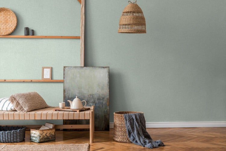 Heller Raum mit hellgrüner Strukturtapete, Holzkommode und Rattandekoration