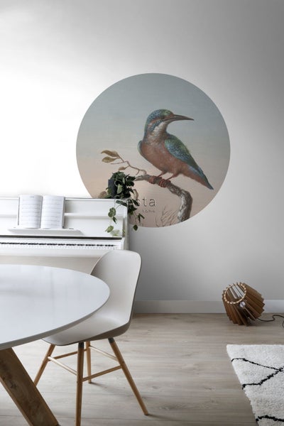 Wohnraum mit Wandbild eines Vogels, weißem Klavier, Esstisch und dekorativer Lampe