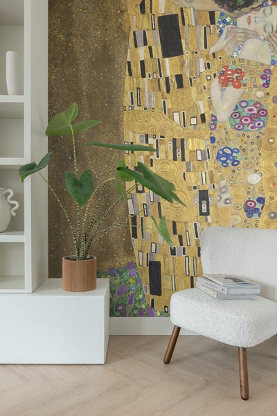 Wohnzimmer mit Kunsttapete, Pflanze, Bücher und einem weißen Stuhl