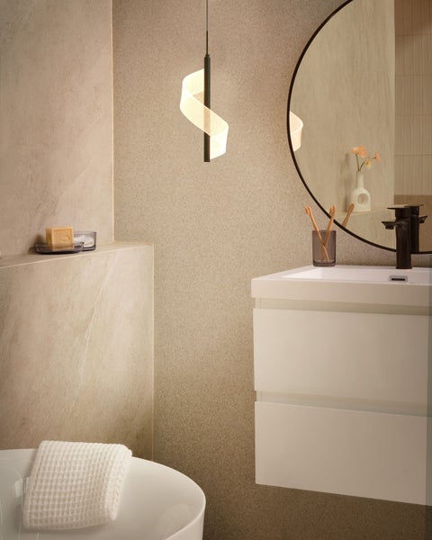 Helles Badezimmer mit Waschtisch, Spiegel und moderner Hängeleuchte