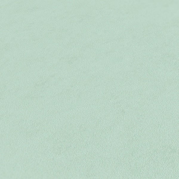 Schlafzimmer mit Bett, Sessel, Regal und Deko-Elementen in harmonischer Farbgestaltung.