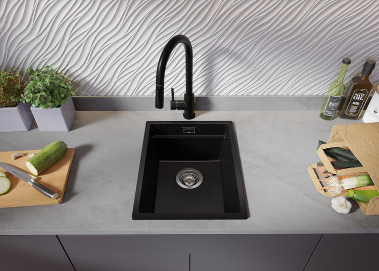 Schwarze Spüle mit Wasserhahn in einer modernen Küche.