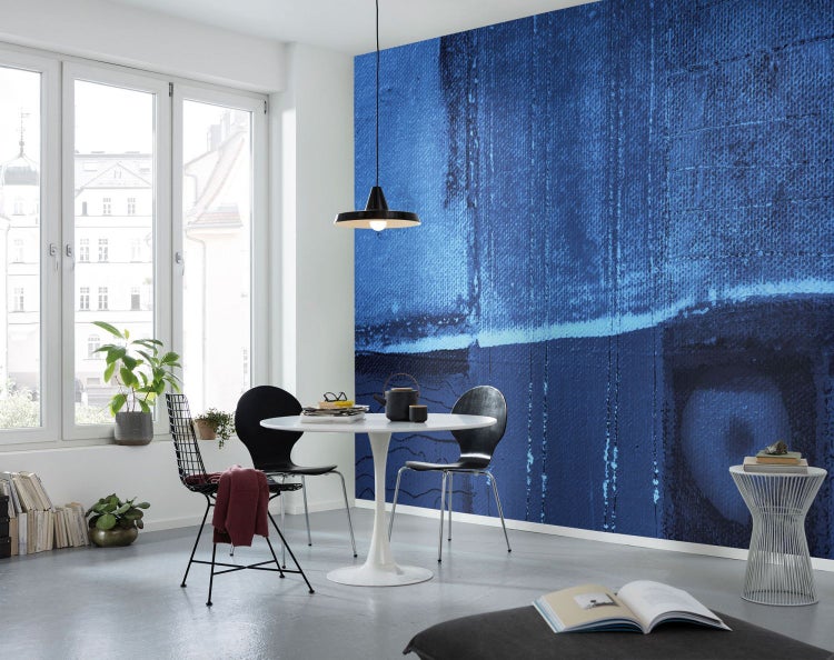 Esszimmer mit Esstisch, Stühlen und einer Wand mit abstraktem Muster