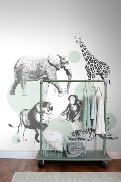 Wandgestaltung mit Tiermotiven, kombiniert mit einem Kleiderständer, Körben und Textilien für ein kinderfreundliches Ambiente.