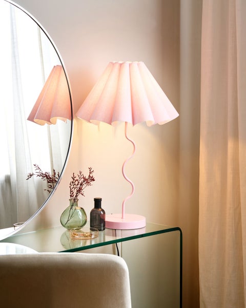 Dekoratives Interieur mit Tischleuchte, Spiegel und Accessoires auf einem Tisch