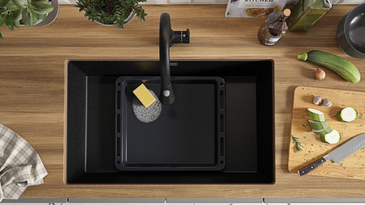 Spüle mit Armatur, Backblech und Spülschwamm in einer Küchenszene