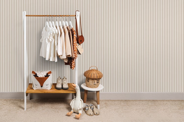 Kinderzimmer mit Kleiderständer, Kleidung, Spielzeug und Dekorationen.