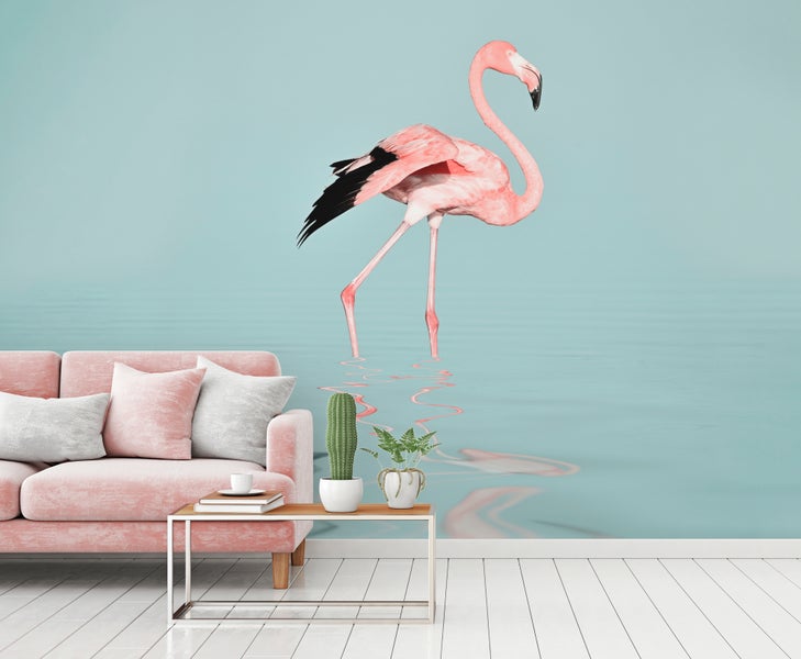 Fototapete mit Flamingo-Motiv in einem hellen Wohnzimmer hinter einem rosa Sofa.