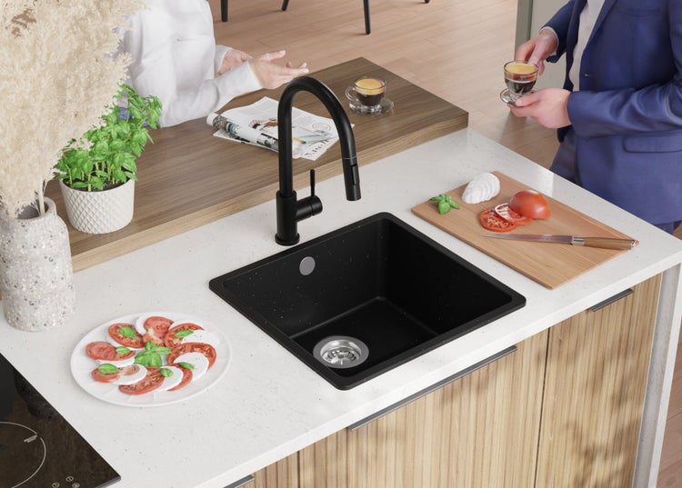 Küchenszene mit Spüle, Armatur, Kochfeld und Lebensmitteln auf einer Arbeitsplatte.