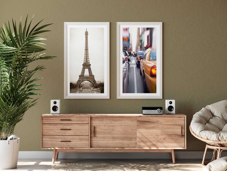 Helles, modernes Wohnzimmer mit strukturierter Wand, Sideboard aus Holz, zwei gerahmten Bildern und einer Zimmerpflanze.