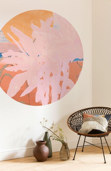 Wohnzimmer mit runder Wanddekoration und Rattansessel