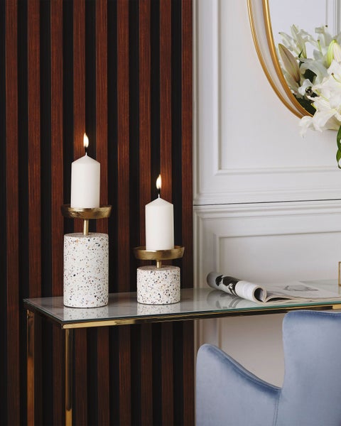 Zwei Kerzenhalter aus Terrazzo auf einem Tisch