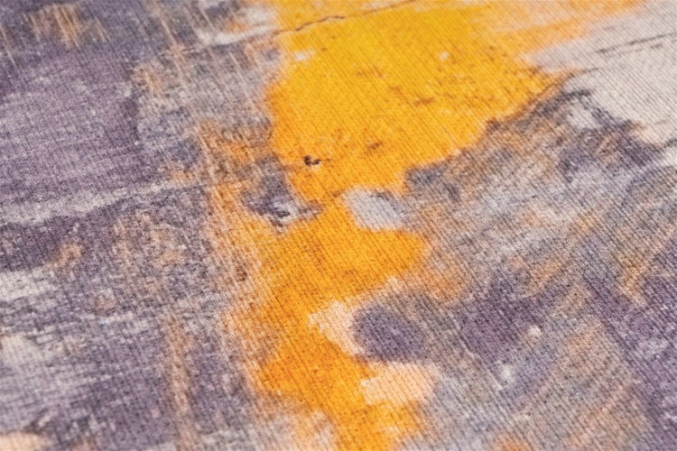 Nahaufnahme eines Teppichs mit abstraktem Muster und fein gerippter Textur.