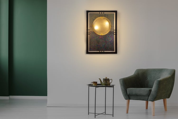 Wohnzimmer mit Sessel, Beistelltisch mit Teekanne und Wandbild