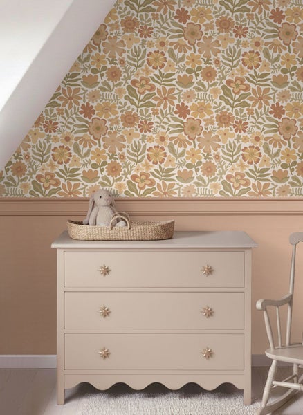Tapete mit retro Blumenmuster in einem hellen Kinderzimmer über einer Kommode und Wandpaneelen.