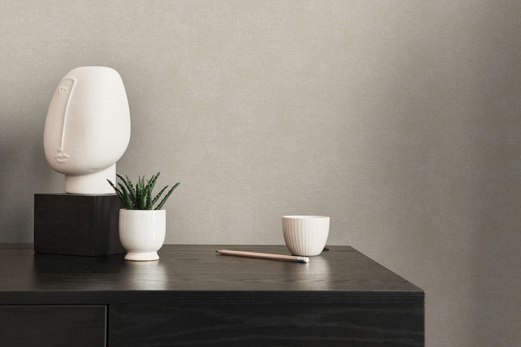 Helles Schlafzimmer mit Bett, Rattansessel, Teppich und Dekoration