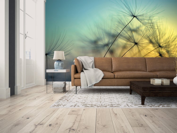 Fototapete mit Löwenzahn-Motiv in einem modernen Wohnzimmer mit braunem Ledersofa und hellem Holzboden.