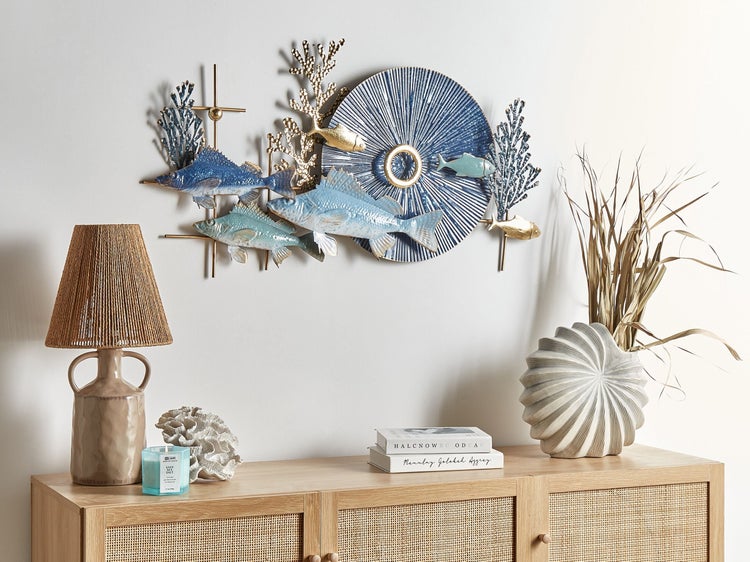 Dekoratives Wandbild mit Fischen, Korallen und kreisförmigem Muster über einem Sideboard mit Lampe und Dekoration.