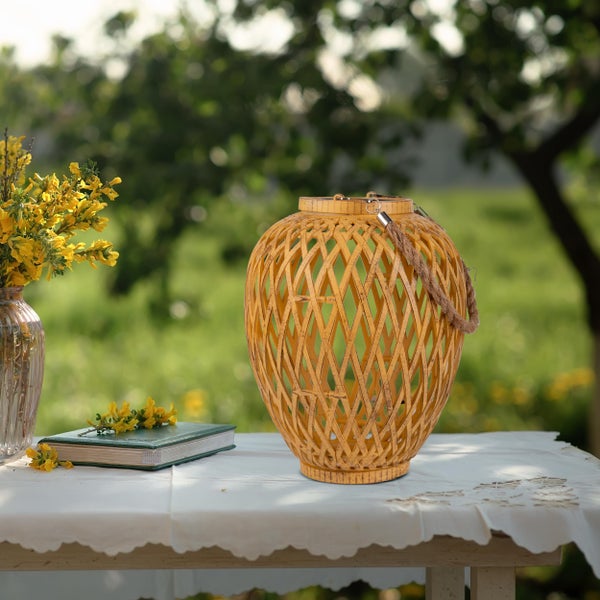 Dekorative Tischszene mit Bambuslaterne, Buch und Blumenarrangement im Garten
