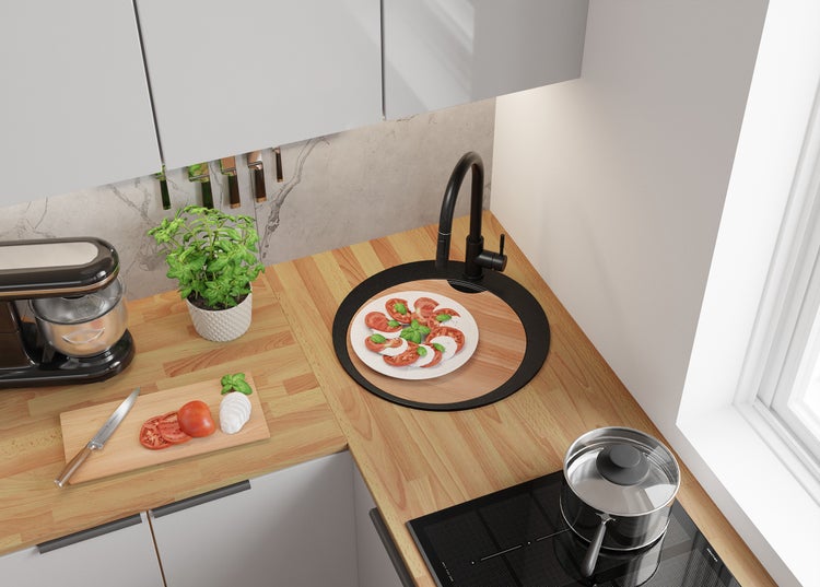 Küchenszene mit Arbeitsplatte, Spüle, Herd und Küchengeräten.