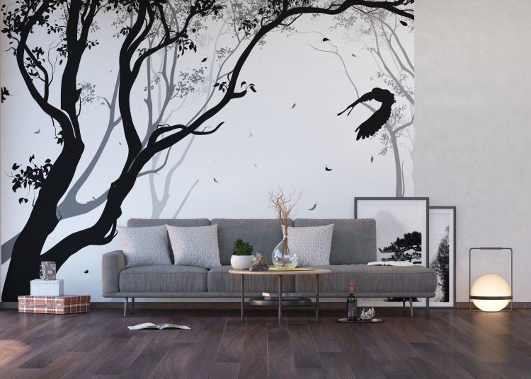 Wohnzimmer mit grauer Couch, Holzboden und Fototapete mit Baummotiv