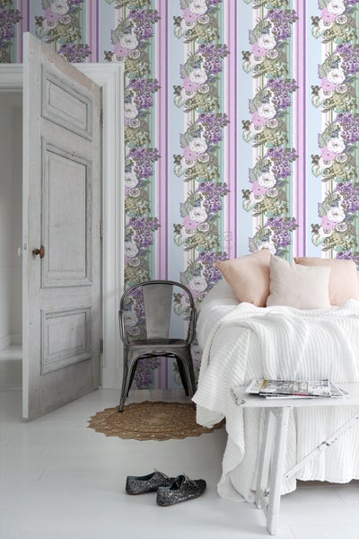 Zimmer mit floral gestreifter Tapete, Bett, Stuhl und offener Tür