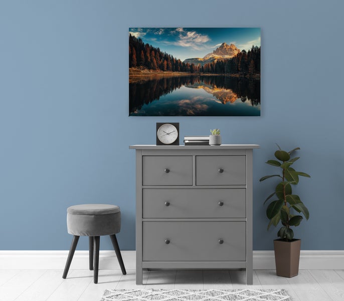 Wandbild mit Bergsee Motiv in Innenraum mit Kommode und Hocker