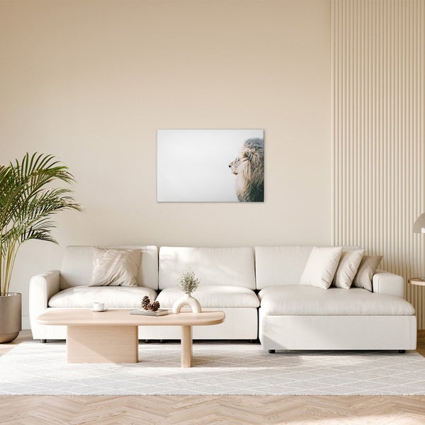 Wohnzimmer mit Sofa, Tisch und einem Wandbild mit einem Löwen.