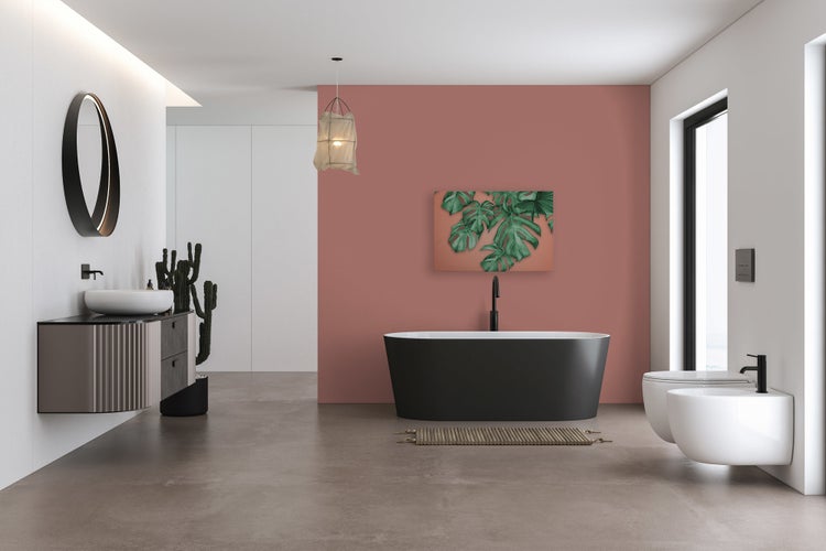 Modernes Badezimmer mit freistehender Badewanne, wandhängendem Waschtisch, hängendem WC und Bidet vor einer Wand in Altrosa.