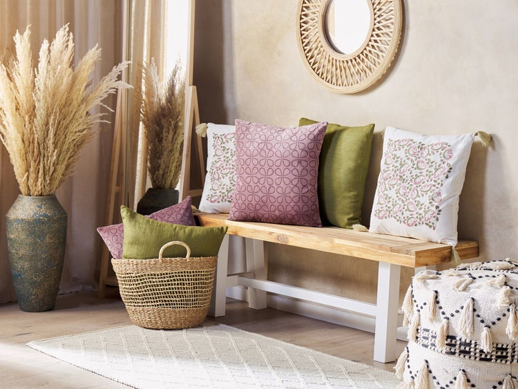 Dekorative Inneneinrichtung mit Bank, Kissen, Vase mit Ziergras, Korb, Teppich und Pouf