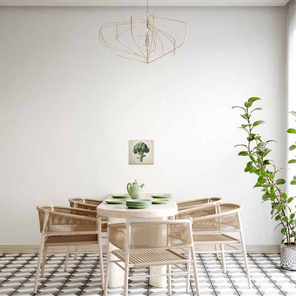 Esszimmer mit Esstisch, Stühlen und einem Wandbild mit Brokkolimotiv