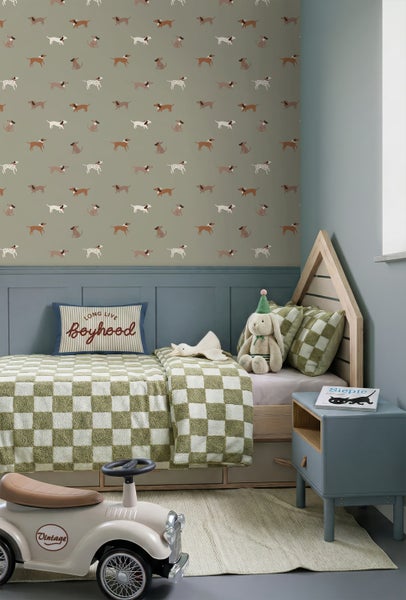 Kinderzimmer mit Tapete mit Hundemotiv, hausförmigem Bett, karierter Bettwäsche, blauem Nachttisch und Spielzeugauto.
