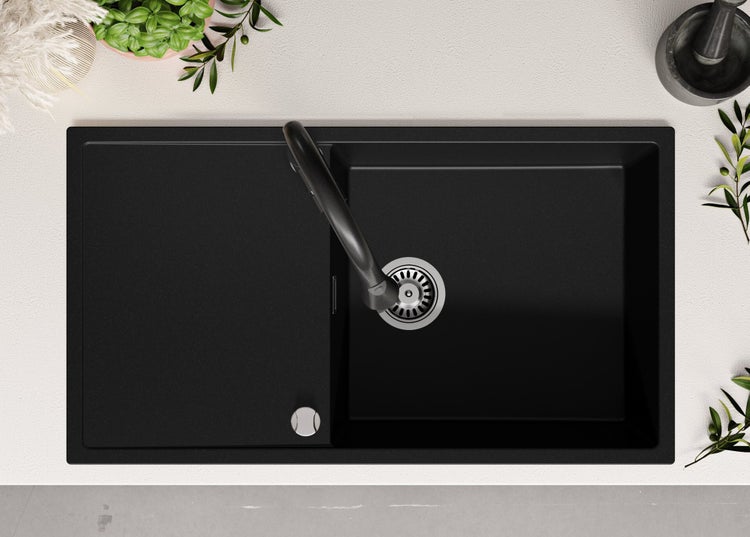 Schwarze Küchenspüle mit Abtropffläche und Armatur von oben