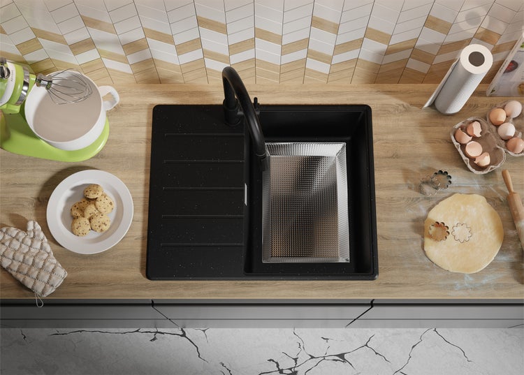 Küchenszene mit schwarzem Spülbecken, Armatur und Küchenutensilien auf einer Arbeitsplatte.