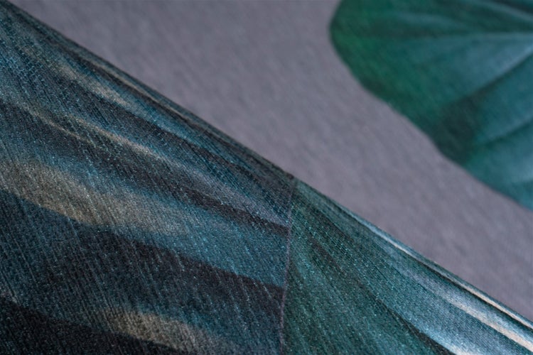 Nahaufnahme einer Vliestapete mit tropischem Blattmuster und strukturierter Oberfläche.