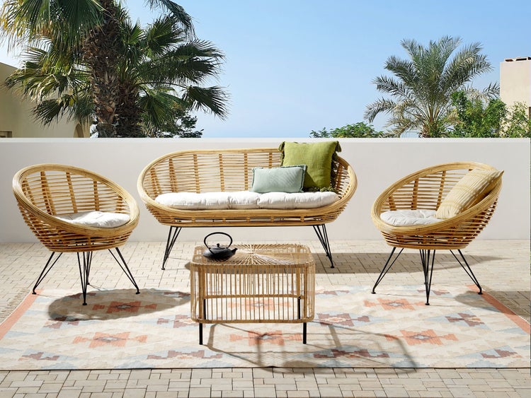 Terrasse mit Rattansitzgruppe bestehend aus Sofa, Sesseln und Tisch