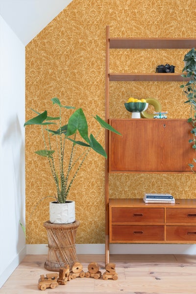 Wohnraum mit gemusterter Tapete, Holzregal und Zimmerpflanze