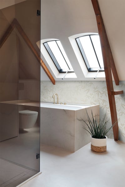 Helles Badezimmer im Dachgeschoss mit Badewanne, Dachfenstern und Duschkabine