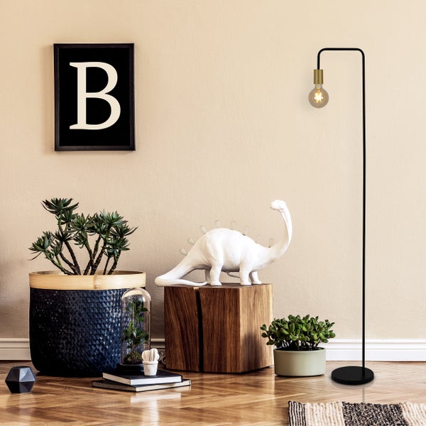 Wohnzimmer-Szene mit Sessel, Stehlampe und dekorativen Elementen für eine gemütliche Atmosphäre.