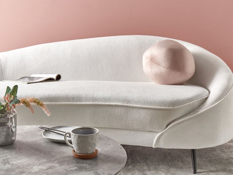 Weißes Sofa mit rundem Kissen und Beistelltisch