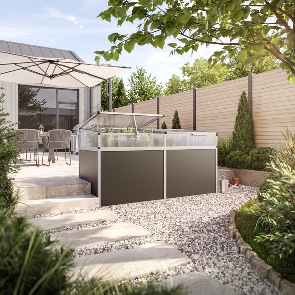 Anthrazitfarbenes Hochbeet mit transparentem Frühbeetaufsatz in einem modernen Garten mit Kiesweg und Terrasse.