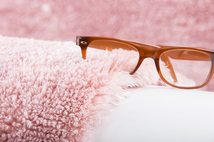 Rosa Hochflor-Teppich mit weicher Shaggy-Struktur und einer braunen Brille auf der Oberfläche.