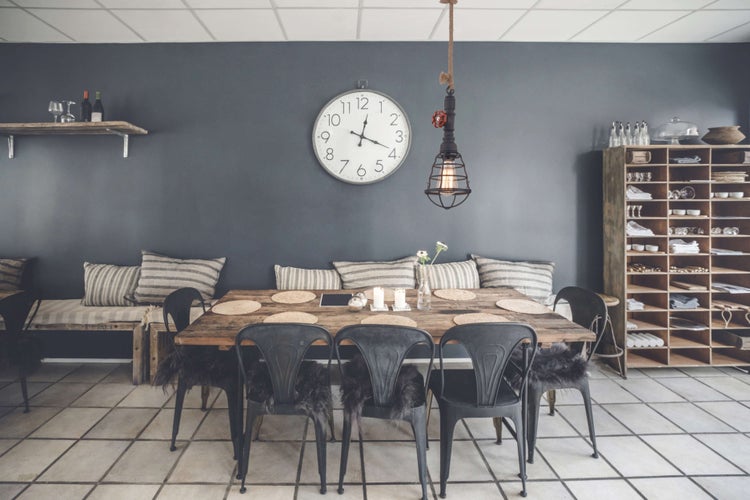 Esszimmer mit Holztisch, Stühlen, Uhr und Regalen